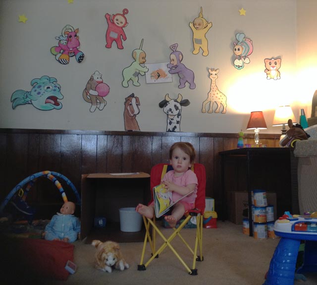 Granddaughter in a child's chair in the living room.