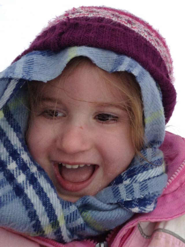 Child wrapped in a scarf, with knit cap.